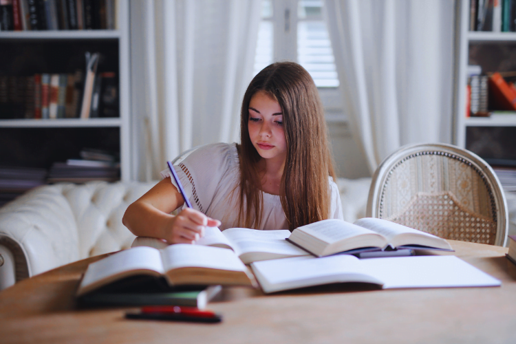 Bewegen en leren, twee handen op één buik 2 Meisje aan het studeren aan tafel