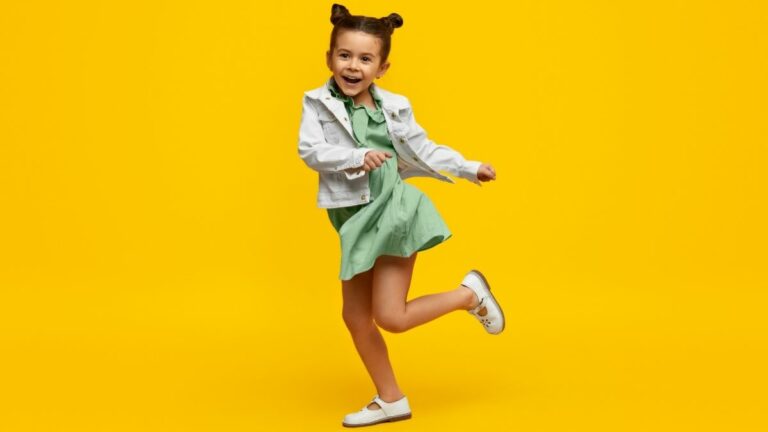 Kleine meisje danst met een gele achtergrond