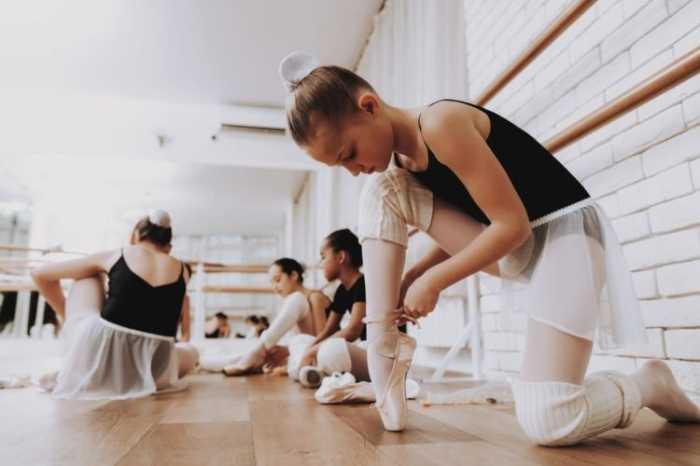 Een ballerina bereidt haar pointes tijdens een les