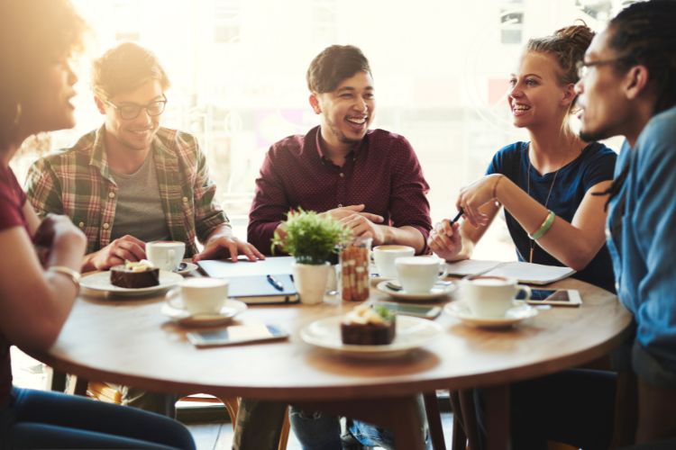 Een groep mensen aan het eten rond een tafel