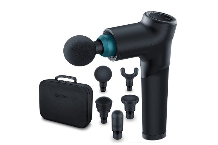 De 10 Beste Massage guns Om Spierpijn Te Verlichten 12 Een zwarte handmassagegun met een bolvormige bevestiging wordt getoond. Eromheen zitten vijf verschillende bevestigingskoppen, waaronder een gevorkte, platte en kogelvormige kop. Een zwarte draagtas met rits met het label "Beurer MG 185 Massagegun" is links van de massagegun en de bevestigingen geplaatst.