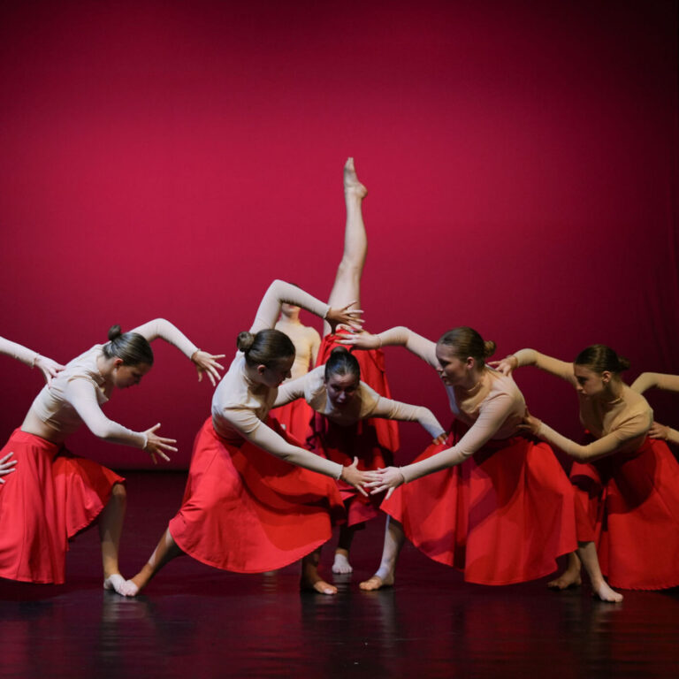 Een Ndigo Teams danseres in een arabesque houding met een been in de lucht.
